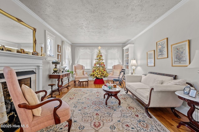 living area featuring a healthy amount of sunlight, wood finished floors, a textured ceiling, and a fireplace