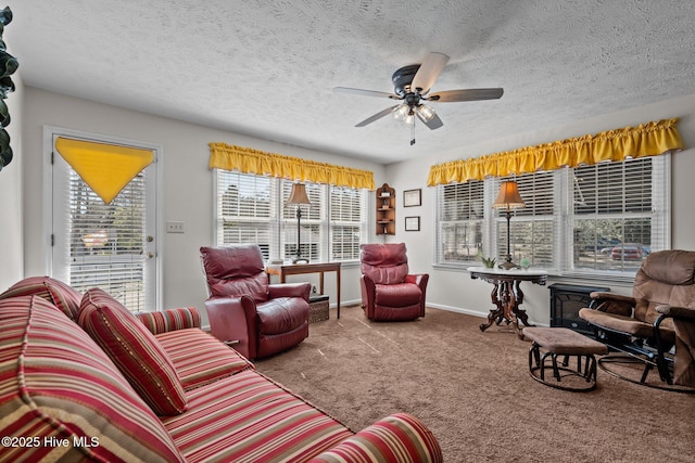 carpeted living room with a ceiling fan, baseboards, and a textured ceiling