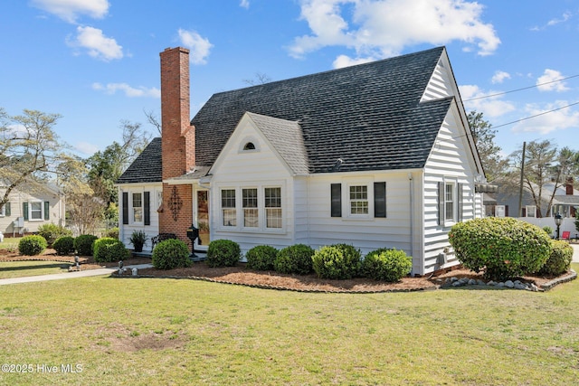 view of front of house featuring a chimney and a front yard