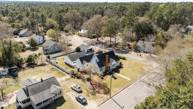 drone / aerial view featuring a residential view and a wooded view