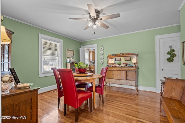 dining area with crown molding, light wood finished floors, baseboards, and a ceiling fan