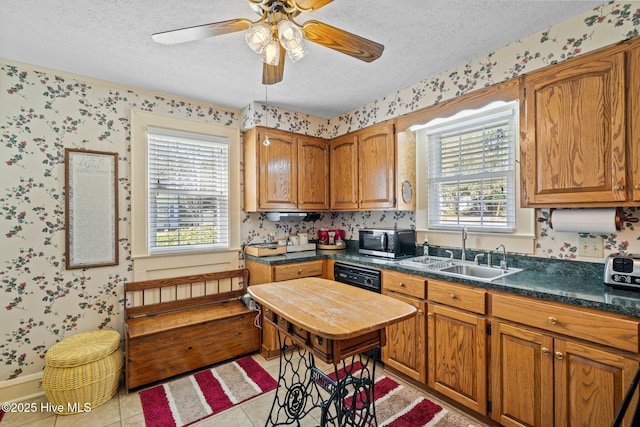 kitchen with stainless steel microwave, wallpapered walls, a textured ceiling, and a sink