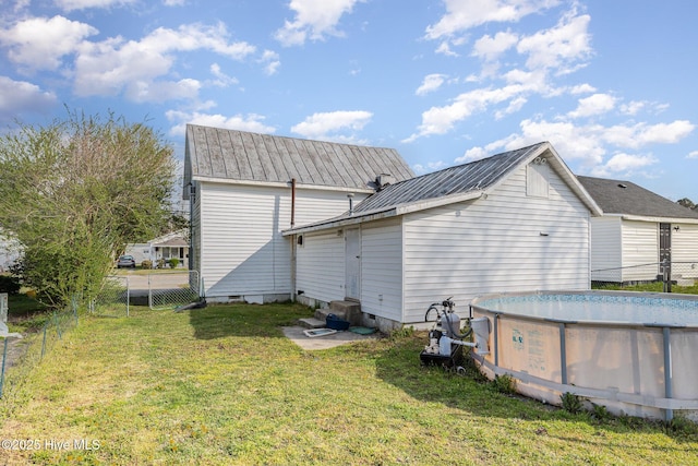 302 N Saratoga St, Stantonsburg, NC 27883 - rear view of house with a lawn, metal roof, and fence