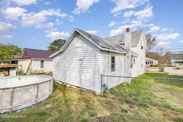 302 N Saratoga St, Stantonsburg, NC 27883 - view of side of home featuring fence, an empty pool, a chimney, and a yard