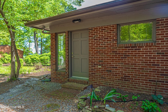 view of exterior entry with brick siding