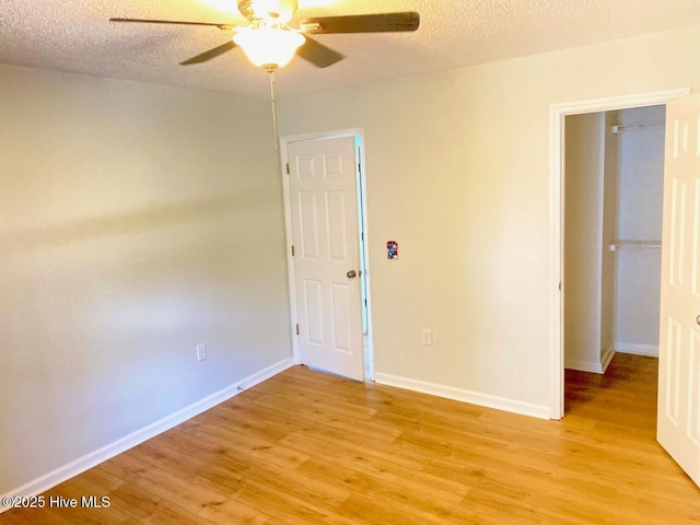 4105 Breezwood Dr Unit 203, Wilmington, NC 28412 - unfurnished bedroom with light wood finished floors, baseboards, ceiling fan, and a textured ceiling
