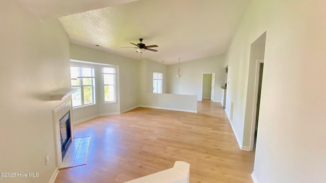 4105 Breezwood Dr Unit 203, Wilmington, NC 28412 - unfurnished living room with light wood-style floors, ceiling fan, a fireplace, baseboards, and lofted ceiling