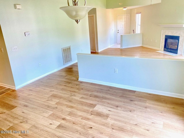 4105 Breezwood Dr Unit 203, Wilmington, NC 28412 - unfurnished living room with light wood finished floors, baseboards, and a tile fireplace