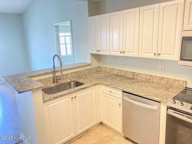 4105 Breezwood Dr Unit 203, Wilmington, NC 28412 - kitchen featuring appliances with stainless steel finishes, a sink, white cabinets, a peninsula, and light stone counters