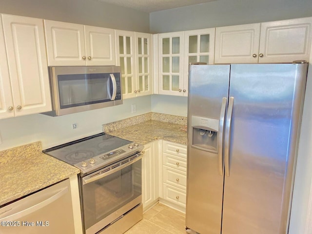 4105 Breezwood Dr Unit 203, Wilmington, NC 28412 - kitchen with stainless steel appliances, white cabinetry, light countertops, and glass insert cabinets