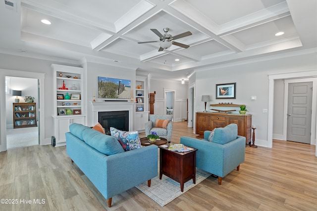 3981 Bay Colony Rd NE, Leland, NC 28451 - living area with a ceiling fan, a glass covered fireplace, light wood-style flooring, beam ceiling, and coffered ceiling