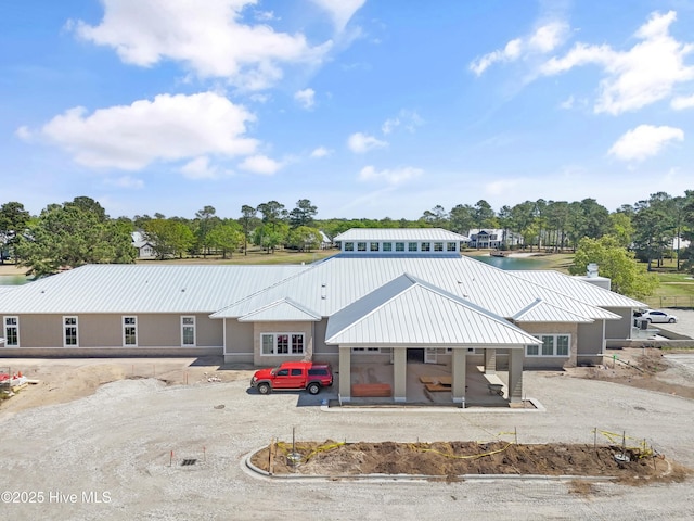 3981 Bay Colony Rd NE, Leland, NC 28451 - rear view of property featuring metal roof, a chimney, and view of scattered trees