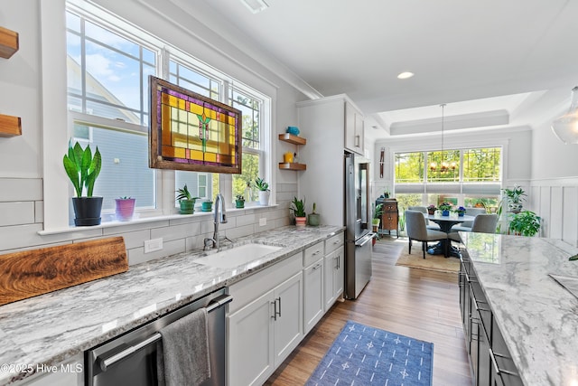 3981 Bay Colony Rd NE, Leland, NC 28451 - kitchen featuring a sink, stainless steel appliances, a chandelier, backsplash, and light wood finished floors