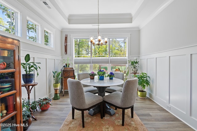 3981 Bay Colony Rd NE, Leland, NC 28451 - dining area with a decorative wall, a tray ceiling, a chandelier, crown molding, and healthy amount of natural light