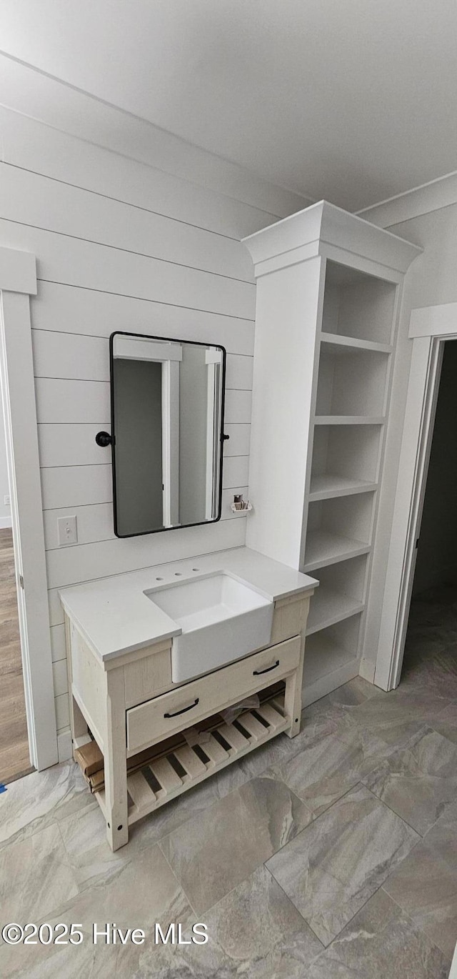 25 Pinewood Dr, Carolina Shores, NC 28467 - bathroom featuring vanity, wood walls, and marble look tiles