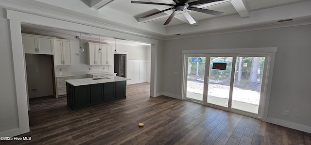 25 Pinewood Dr, Carolina Shores, NC 28467 - kitchen featuring white cabinetry, ceiling fan, beamed ceiling, light countertops, and a center island
