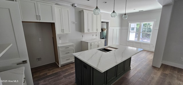 25 Pinewood Dr, Carolina Shores, NC 28467 - kitchen with light stone countertops, dark wood finished floors, a kitchen island, white cabinets, and crown molding