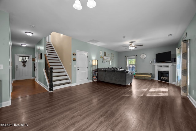 259 Luther Banks Rd, Richlands, NC 28574 - living room with dark wood-style floors, baseboards, stairway, ceiling fan, and a fireplace