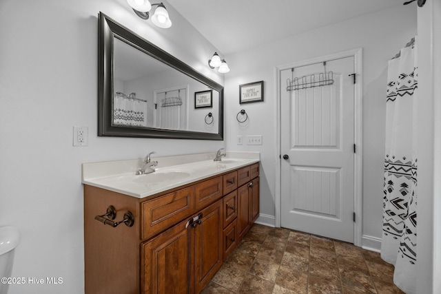 259 Luther Banks Rd, Richlands, NC 28574 - bathroom with baseboards, stone finish floor, a sink, and double vanity