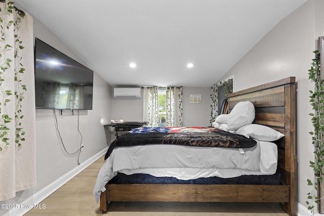 bedroom featuring recessed lighting, a wall mounted air conditioner, vaulted ceiling, wood finished floors, and baseboards