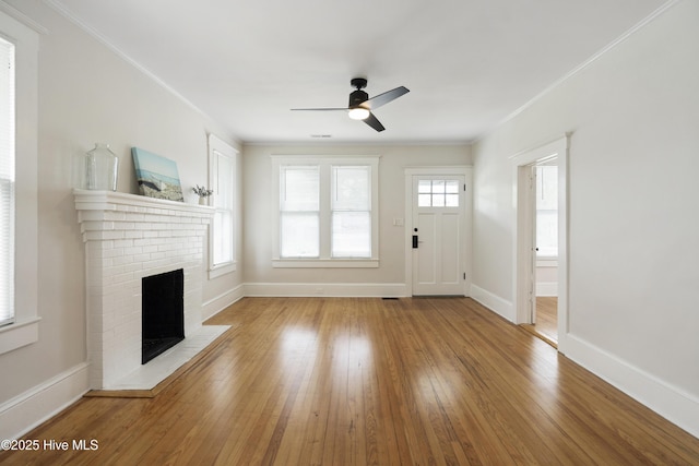 unfurnished living room with crown molding, ceiling fan, hardwood / wood-style flooring, and a fireplace