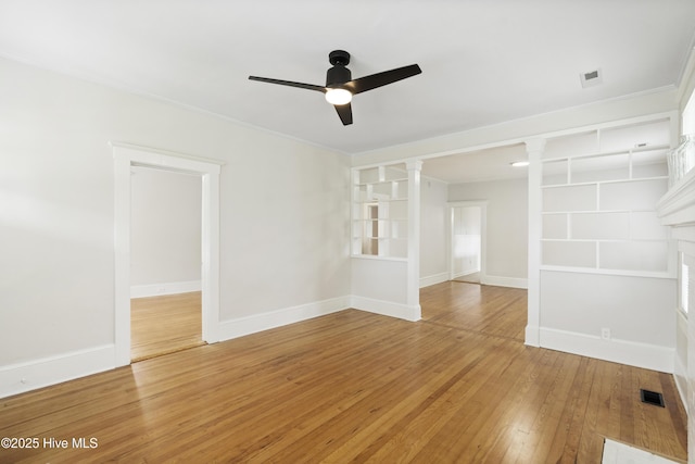 unfurnished room with ornate columns, ceiling fan, light wood finished floors, and visible vents