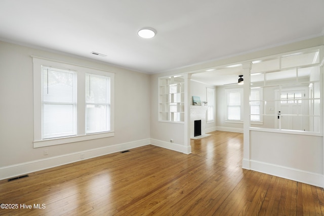 unfurnished living room featuring visible vents, baseboards, and ceiling fan