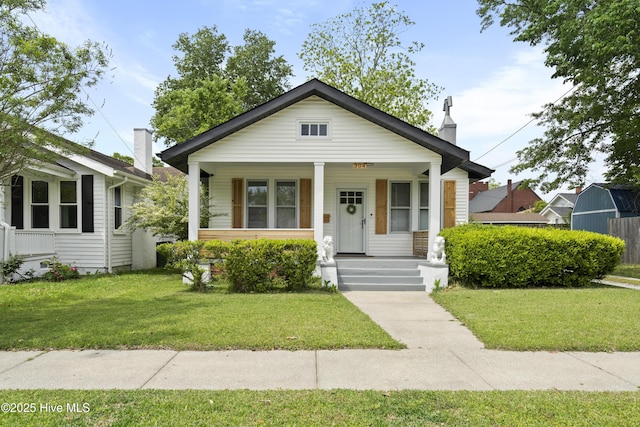 bungalow featuring covered porch and a front lawn