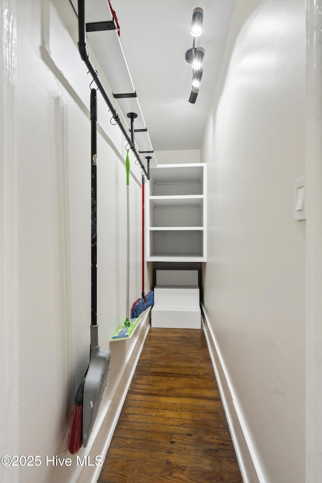 walk in closet with wood finished floors