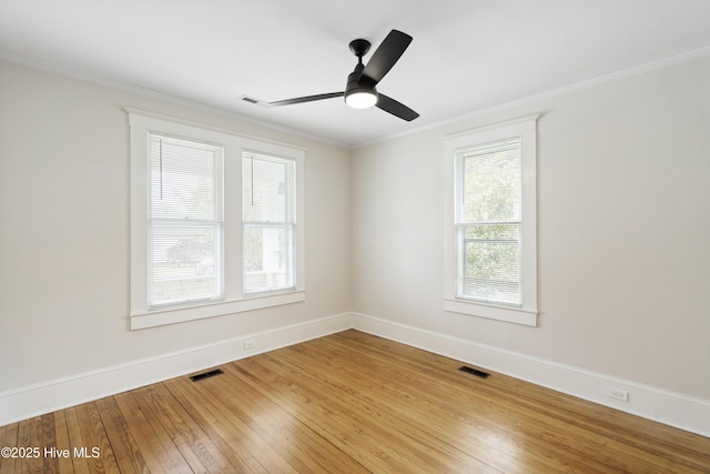 spare room featuring visible vents, crown molding, baseboards, and plenty of natural light