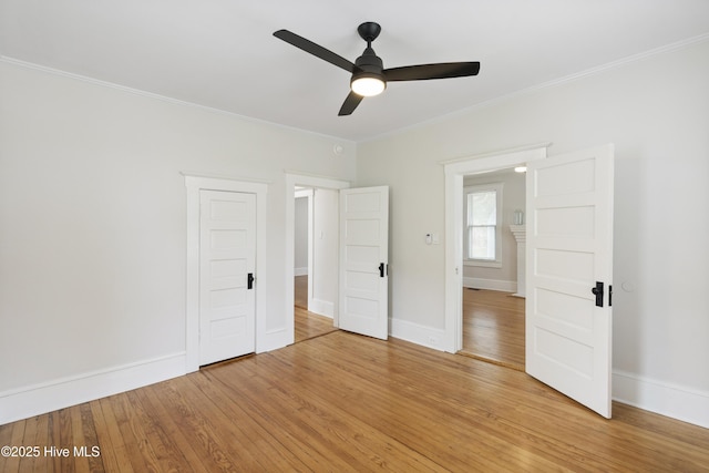 unfurnished bedroom with baseboards, ornamental molding, light wood finished floors, and a ceiling fan