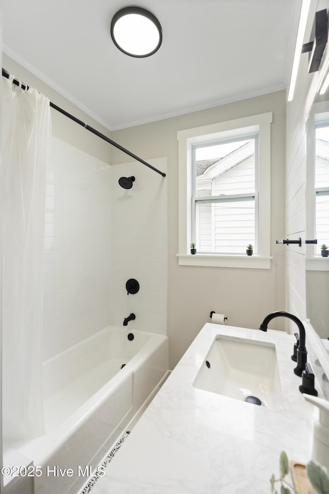 bathroom with crown molding, a healthy amount of sunlight, a sink, and shower / bath combo