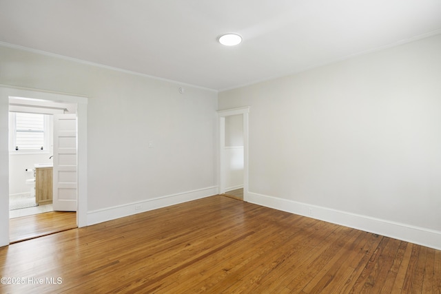 empty room with baseboards, ornamental molding, and hardwood / wood-style flooring