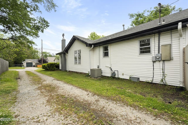 view of side of home with central air condition unit and a chimney