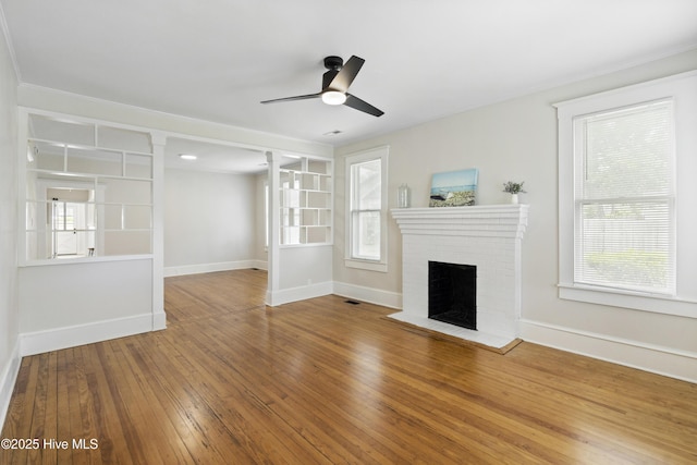 unfurnished living room featuring a brick fireplace, baseboards, ceiling fan, and wood-type flooring