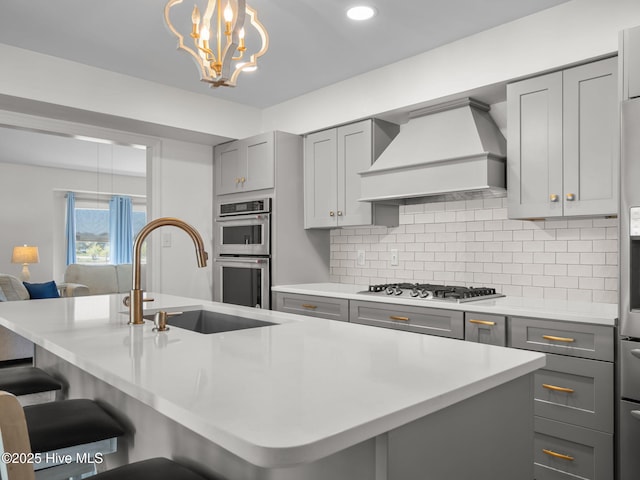 267 Live Oak Rd, Newport, NC 28570 - kitchen with gray cabinets, stainless steel appliances, custom exhaust hood, light countertops, and tasteful backsplash