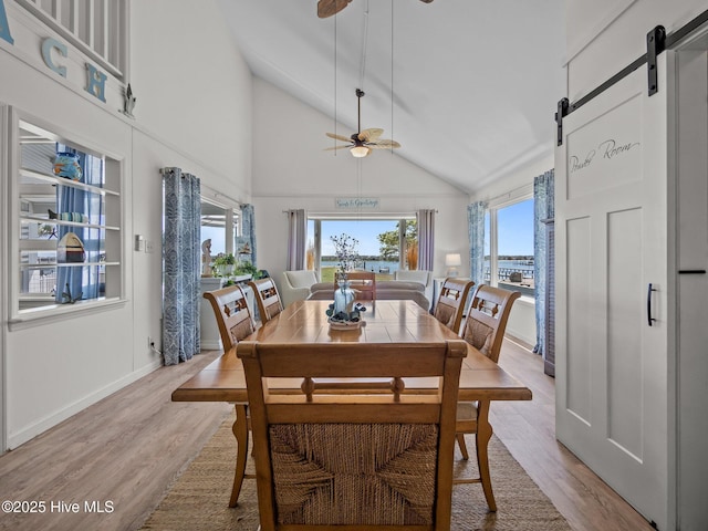 267 Live Oak Rd, Newport, NC 28570 - dining area with a barn door, a ceiling fan, wood finished floors, baseboards, and high vaulted ceiling