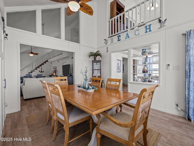 267 Live Oak Rd, Newport, NC 28570 - dining space featuring a ceiling fan, wood finished floors, stairway, baseboards, and a high ceiling