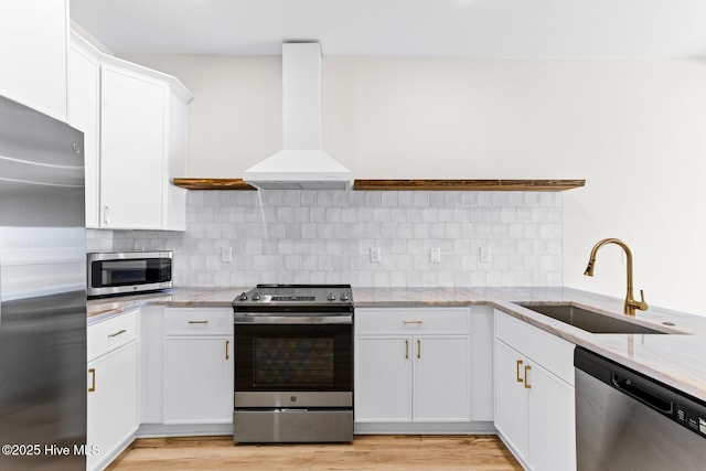 1800 Canal Dr Unit 309, Carolina Beach, NC 28428 - kitchen featuring appliances with stainless steel finishes, a sink, custom exhaust hood, light stone countertops, and white cabinetry