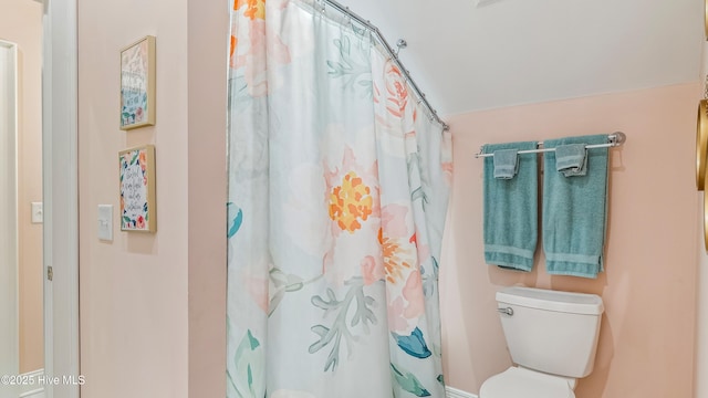 bathroom featuring a shower with shower curtain and toilet
