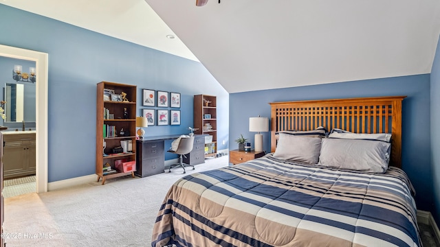 carpeted bedroom with connected bathroom, vaulted ceiling, and baseboards
