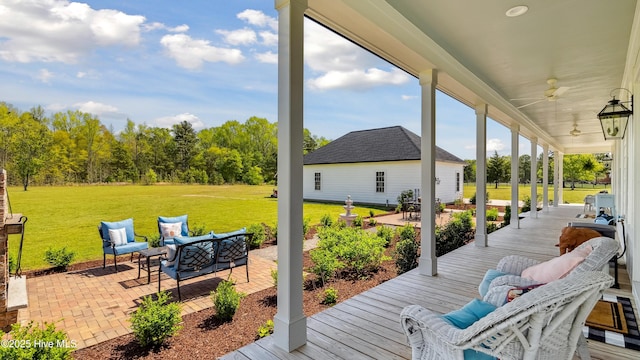 deck with a lawn, outdoor lounge area, a ceiling fan, and a patio