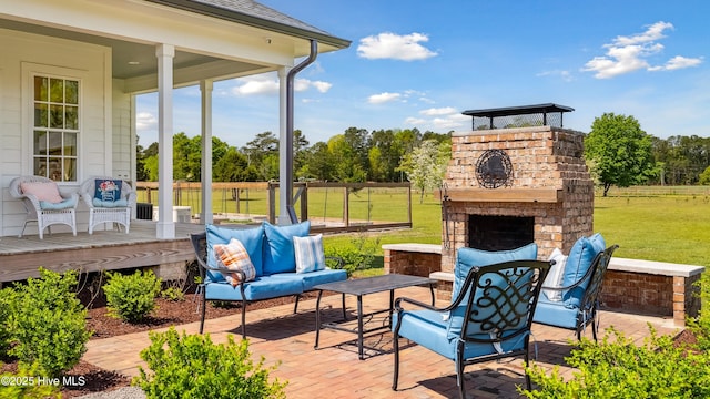 view of patio / terrace with a wooden deck, an outdoor living space with a fireplace, and fence