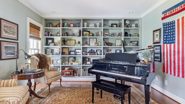 sitting room with baseboards, ornamental molding, and wood finished floors