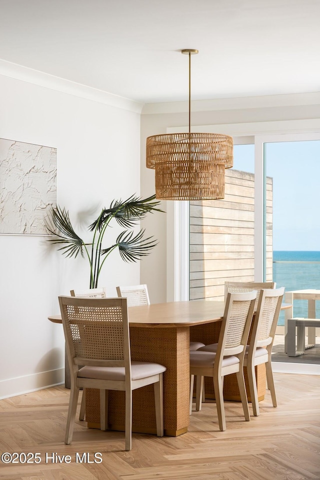 dining room featuring a chandelier, healthy amount of natural light, crown molding, and baseboards