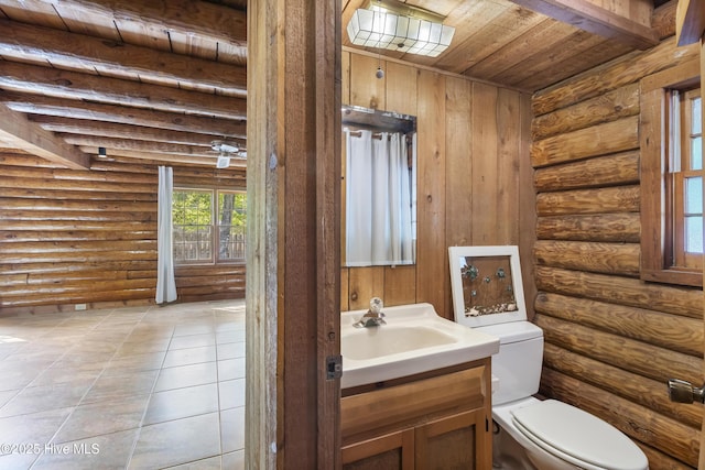 half bath with tile patterned floors, rustic walls, toilet, wood ceiling, and vanity