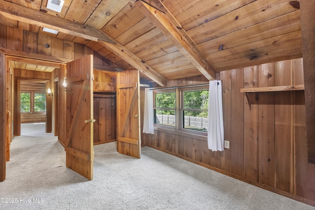 interior space featuring wood ceiling, lofted ceiling with beams, and carpet