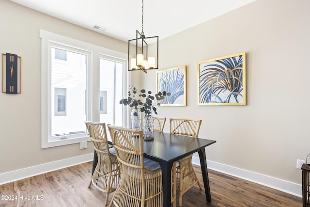 dining space with baseboards, wood finished floors, a chandelier, and visible vents