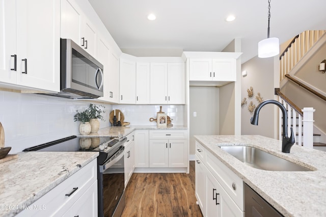 kitchen featuring stainless steel appliances, a sink, white cabinetry, and dark wood finished floors