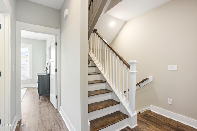 staircase with baseboards and wood finished floors